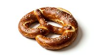 Freshly baked pretzel with coarse salt crystals on white background, isolated for bakery, food packaging, menu design and culinary projects.