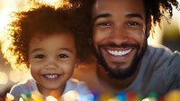 African American father and daughter with natural curly hair share genuine smiles in warm sunset lighting with colorful bokeh background, expressing joy and family bonding.