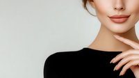 Young woman with natural makeup touching face showing healthy glowing skin and lips against neutral background for skincare and beauty concepts.