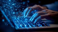 Hands typing on illuminated laptop keyboard in dark room with glowing blue particles and light effects, representing cybersecurity and digital technology.