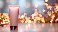 Pink cosmetic tube on reflective surface against blurred golden bokeh lights background, luxury skincare product photography for beauty and wellness marketing.