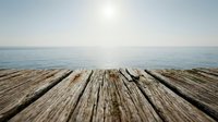 Wooden pier or dock extending toward calm ocean waters under bright sunlight, suitable for travel, vacation, and coastal lifestyle designs.