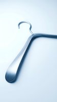 Sleek metallic clothes hanger with brushed aluminum finish on a light background, conveying modern minimalism for fashion and retail concepts.