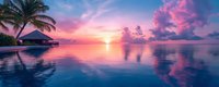 Panoramic view of tropical sunset over calm ocean waters with overwater bungalow and palm tree silhouette against dramatic pink and purple sky reflections.