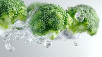 Fresh broccoli florets splashing in clear water with bubbles and droplets against white background, macro food photography for healthy eating concept.