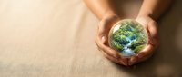 Hands gently holding miniature Earth globe showing environmental protection and sustainability concept for eco-friendly campaigns and green initiatives.