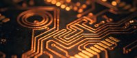 Close-up macro view of golden copper circuit board traces and electronic pathways with warm lighting creating intricate patterns for technology designs.