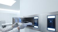 Futuristic laboratory interior with scientist in white coat conducting research at high-tech workstation with digital displays and modern equipment.