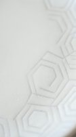 Subtle geometric hexagonal pattern embossed on white textured surface with soft shadows creating minimalist modern background for design projects.