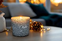 Cozy home interior with decorative white ceramic candle holder, warm fairy lights and pine cone on coffee table creating ambient atmosphere for relaxation.