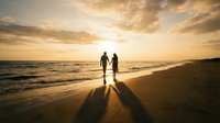 Romantic couple holding hands walking on beach at golden sunset with dramatic sky and ocean waves creating silhouettes on sand for wedding anniversary concepts.