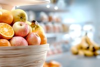 Fresh mixed fruits in wicker basket on kitchen counter with blurred background. Healthy eating and nutrition concept for cooking and meal preparation.