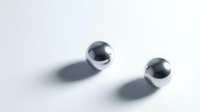 Two shiny chrome metal spheres casting soft shadows on a light gray surface, showcasing reflective metallic texture for modern design concepts.