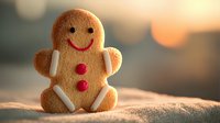 Smiling gingerbread man cookie with red buttons on sandy surface against blurred sunset background, perfect for holiday baking and festive food concepts.
