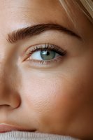 Close-up view of green eye with long eyelashes and well-groomed eyebrow showing natural beauty and flawless skin texture for cosmetic and beauty industry.