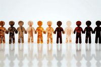 Diverse wooden figures holding hands in unity row against white background, symbolizing racial equality, inclusion and community connection.