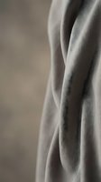 Soft beige fabric with elegant draping and natural folds creates luxurious textile background for fashion and interior design projects.