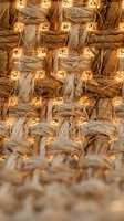 Woven rattan texture with warm LED string lights creating cozy ambient lighting for home decor and interior design projects.