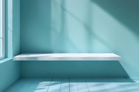 Empty white shelf on turquoise wall with window light and shadows creating minimalist interior scene, suitable for product display and mockup designs.