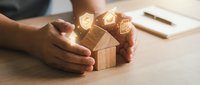 Hands holding wooden blocks with glowing light bulb icons symbolizing innovation, ideas, and business growth strategy for startups and entrepreneurship concepts.