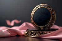Ornate golden hand mirror with intricate floral patterns resting on flowing pink silk fabric against dark background for luxury beauty concepts.