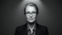 Mature woman with short gray hair and eyeglasses wearing dark blazer and collared shirt, professional headshot for corporate, business, and executive portraits.