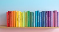 Colorful rainbow books arranged on wooden shelf creating vibrant spectrum from red to purple spines for education and learning concepts.