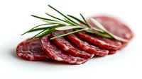 Sliced dry-cured salami with fresh rosemary sprig arranged on white background, showcasing texture and rich red color of premium cured meat product.