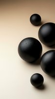 Black spheres with matte finish arranged on neutral beige background for modern minimalist design and contemporary decor applications.