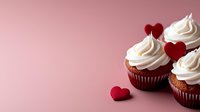 Red velvet cupcakes with cream cheese frosting and red heart decorations on pink background, romantic dessert for Valentine's Day celebration or wedding party.