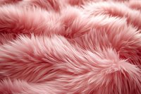 Soft pink faux fur texture background with fluffy fibers and gentle waves creating luxurious plush surface pattern. Suitable for fashion and interior design projects.