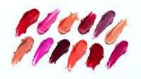 Colorful lipstick smears collection isolated on white background, showcasing vibrant shades from nude to bold red, pink, and berry tones.