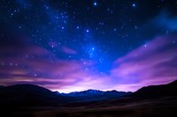 Stunning night sky with vibrant purple and blue colors over mountain landscape. Starry cosmic scene with dramatic twilight atmosphere for backgrounds.