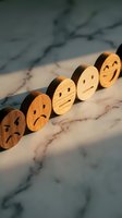 Wooden emotion faces arranged from sad to happy on marble surface representing customer satisfaction rating and feedback concept for business improvement.