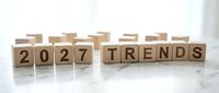 Wooden letter cubes spelling 2027 Trends arranged on a marble surface, representing future business forecasting and planning concepts.