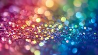 Colorful glitter bokeh background with rainbow spectrum colors from pink to blue creating magical sparkle effect. Macro photography of shimmering texture.