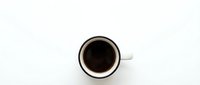 White coffee cup with black coffee viewed from above on clean white background isolated for design projects and commercial use.