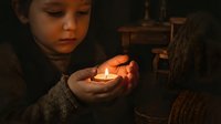 Young girl holding glowing candle flame in cupped hands creating warm atmospheric light in dark rustic interior setting for meditation and spiritual concepts.