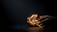 Hands cupped together holding glowing flames against dark background, symbolizing protection, care, energy and spiritual power for creative projects.