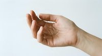 Caucasian hand holding a clump of fallen hair on white background, depicting hair loss, alopecia, and scalp health concerns.