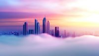 Modern skyscrapers rising above dense fog at sunrise, creating dramatic cityscape silhouette against pink and purple sky. Ethereal urban landscape for business concepts.