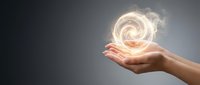 Hand holding glowing spiral energy orb against gray background, representing innovation, power, and potential for business and technology concepts.