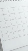 Blank spiral wall calendar with empty grid cells, minimalist white design for planning, scheduling, and organizing monthly events.