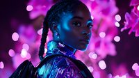 Young African woman with braided hair in futuristic fashion against neon pink and blue lights background, dramatic portrait with glowing makeup and metallic collar.