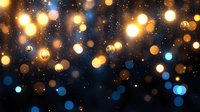 Magical glowing golden and blue bokeh lights scattered on dark background with sparkles and glitter effect creates festive atmosphere.