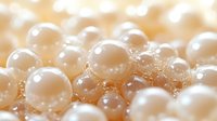 Luminous white pearls in soft focus macro shot showing luxurious texture and natural luster with light bokeh effect, elegant jewelry background.