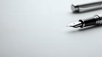 Elegant black fountain pen with silver accents on clean white surface, professional writing instrument for business correspondence and formal documents.