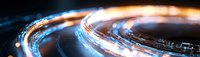 Glowing blue light trails forming circular motion paths against dark background, creating dynamic streaks of illumination and energy flow effects.