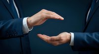 Businessman hands in protective gesture showing care and security concept for insurance coverage and risk management in corporate environment.