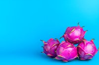 Vibrant pink dragon fruit arranged on bright blue background creating bold contrast and modern minimal composition for food photography and healthy eating concept.